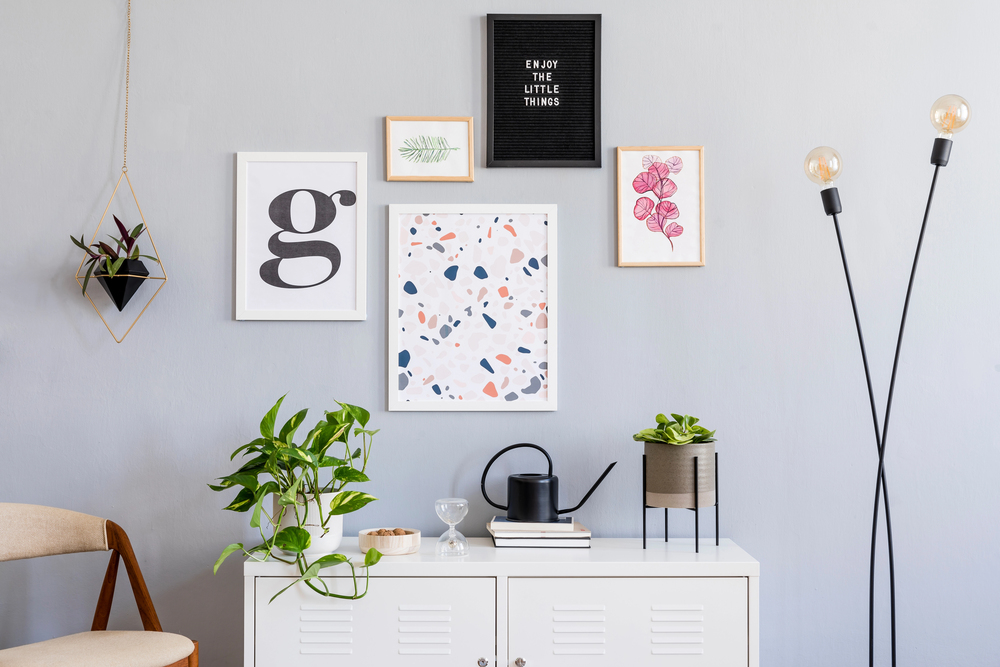 Cadres design et divers objets décoratifs sur un mur gris clair