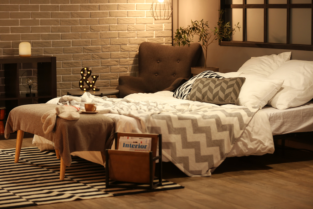 Chambre cosy style industriel avec murs en brique grise